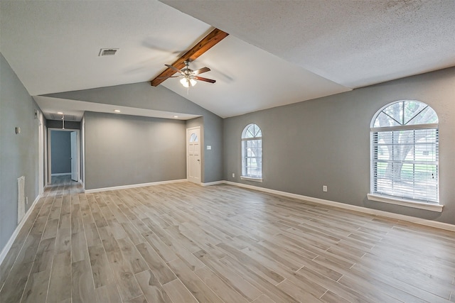 unfurnished room with ceiling fan, a textured ceiling, light wood-type flooring, and lofted ceiling with beams