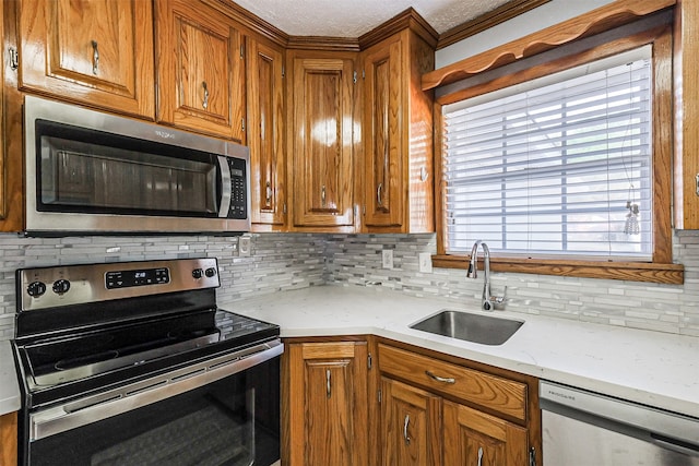 kitchen featuring backsplash, sink, light stone counters, and stainless steel appliances