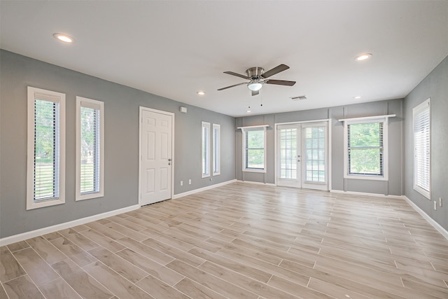 empty room featuring light wood-type flooring, french doors, and ceiling fan