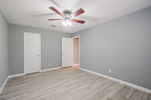 empty room with ceiling fan and light hardwood / wood-style flooring