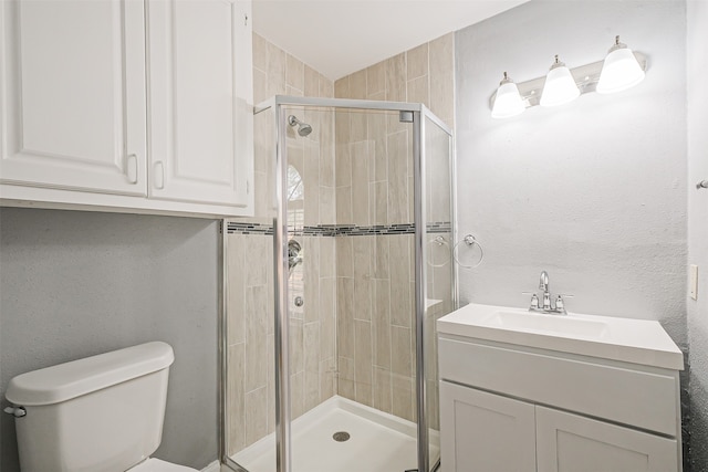 bathroom featuring toilet, vanity, and walk in shower