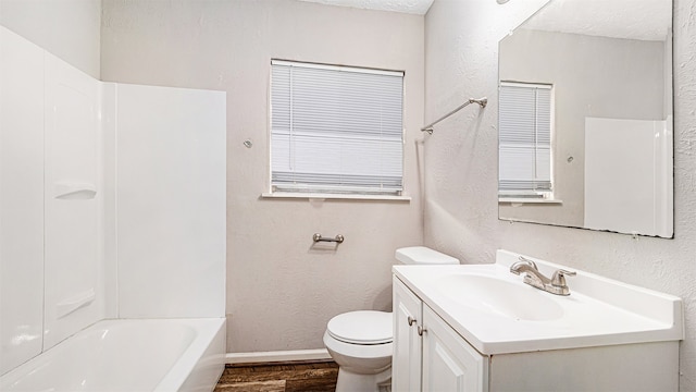 full bathroom featuring wood-type flooring, bathing tub / shower combination, toilet, and vanity