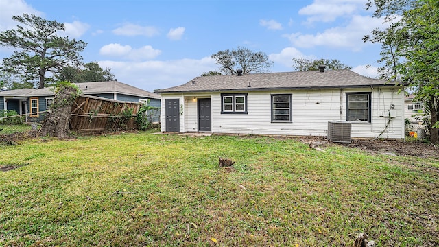 back of house featuring central AC unit and a yard