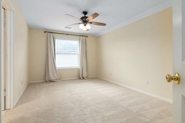 empty room featuring light colored carpet, ceiling fan, and crown molding