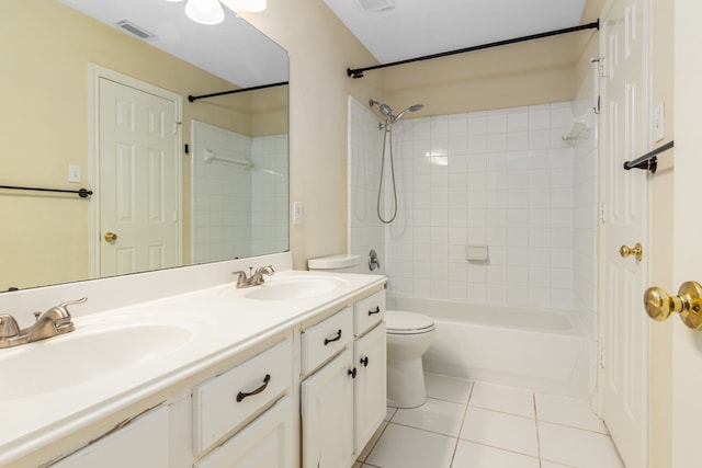 full bathroom featuring toilet, vanity, tiled shower / bath combo, and tile patterned floors