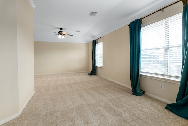 spare room featuring ceiling fan, vaulted ceiling, light colored carpet, and ornamental molding