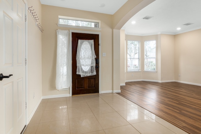 foyer entrance featuring light hardwood / wood-style floors and crown molding