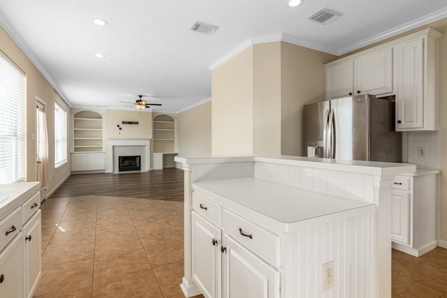 kitchen featuring light hardwood / wood-style floors, ceiling fan, a kitchen island, and stainless steel fridge with ice dispenser