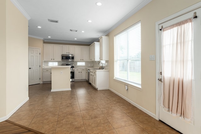 kitchen featuring a kitchen island, sink, a healthy amount of sunlight, and stainless steel appliances