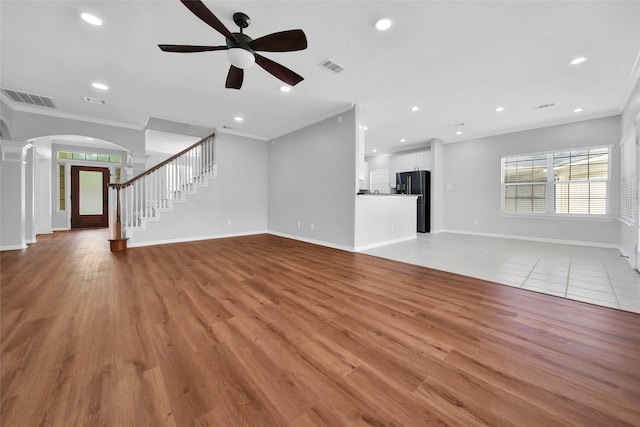 unfurnished living room featuring crown molding, ceiling fan, light hardwood / wood-style flooring, and ornate columns