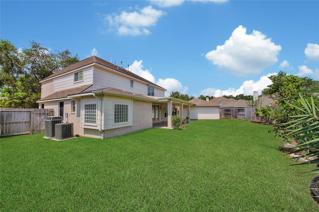 rear view of property featuring a yard and central AC