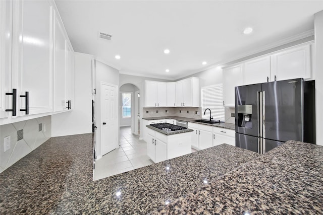 kitchen with sink, light tile patterned floors, appliances with stainless steel finishes, tasteful backsplash, and white cabinets