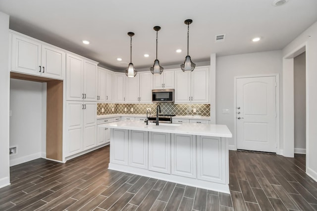 6804 Westview Dr Unit 3405, Houston, TX 77055 - kitchen featuring stainless steel microwave, baseboards, light countertops, dark wood finished floors, and recessed lighting
