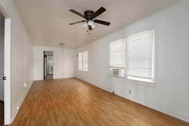 empty room featuring a wealth of natural light, ceiling fan, cooling unit, and light wood-type flooring