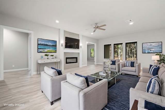 living room with ceiling fan and light hardwood / wood-style floors