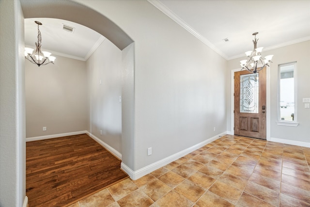 entrance foyer featuring light wood-type flooring, a notable chandelier, and ornamental molding