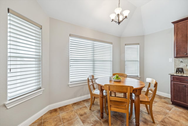 dining space with a healthy amount of sunlight, lofted ceiling, light tile patterned floors, and an inviting chandelier