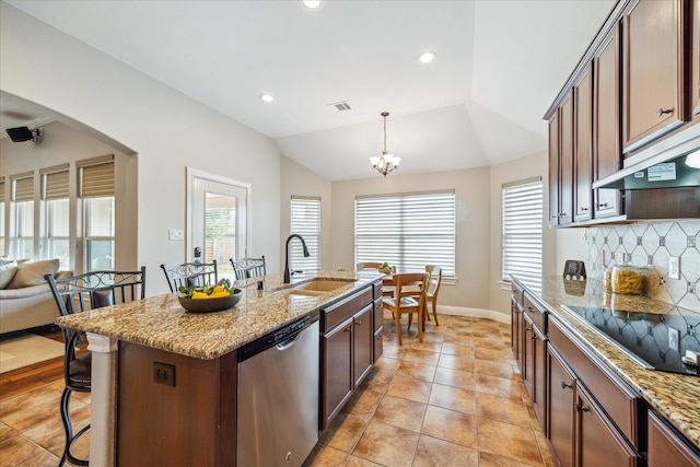 kitchen featuring dishwasher, lofted ceiling, a kitchen island with sink, hanging light fixtures, and sink