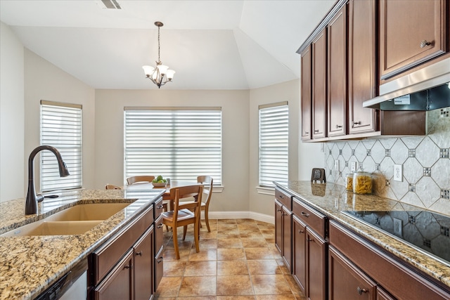 kitchen with light stone countertops, sink, decorative light fixtures, vaulted ceiling, and black electric cooktop