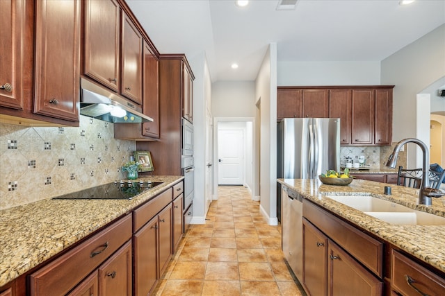 kitchen featuring decorative backsplash, appliances with stainless steel finishes, light stone counters, sink, and light tile patterned flooring