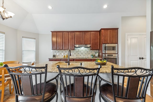 kitchen featuring tasteful backsplash, stainless steel appliances, sink, decorative light fixtures, and lofted ceiling