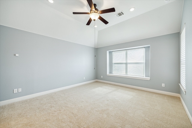 spare room featuring light carpet, ceiling fan, and lofted ceiling