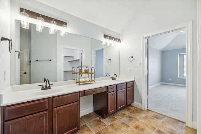 bathroom with tile patterned flooring, vanity, and lofted ceiling