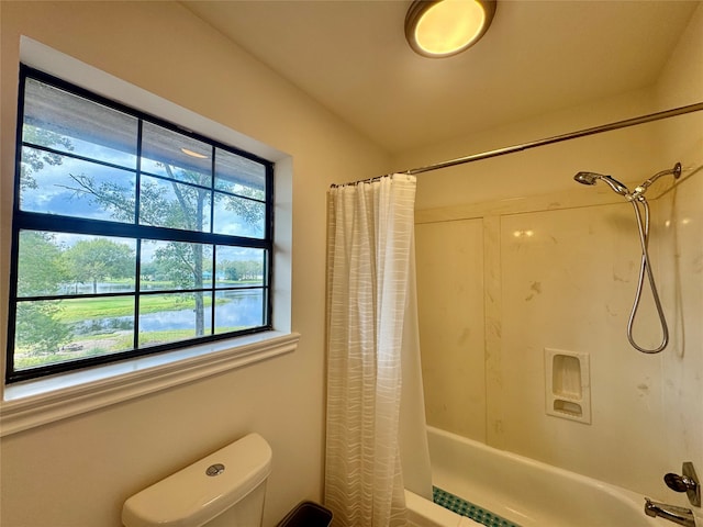 bathroom with shower / bathtub combination with curtain and toilet