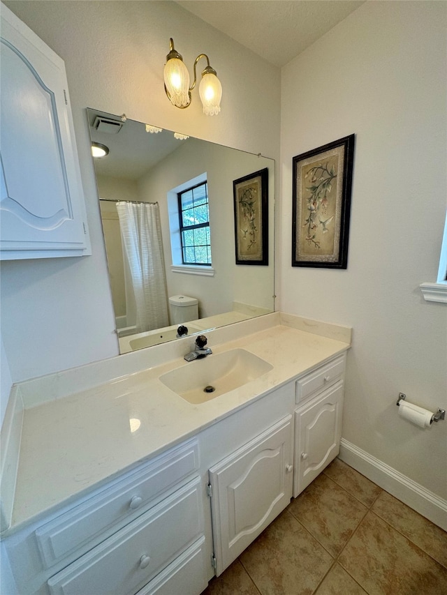 bathroom featuring toilet, walk in shower, vanity, and tile patterned floors