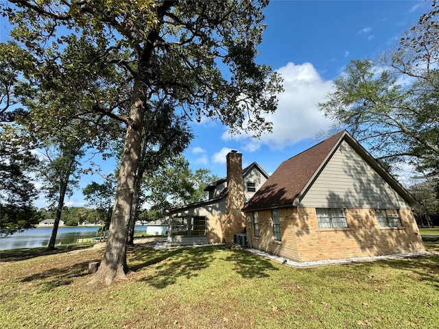 view of side of home with a lawn and a water view