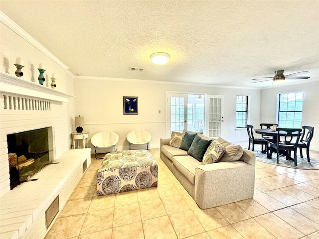 tiled living room featuring french doors, a fireplace, crown molding, a textured ceiling, and ceiling fan