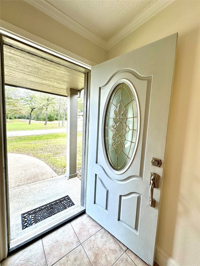 tiled foyer entrance with a textured ceiling, a healthy amount of sunlight, and crown molding