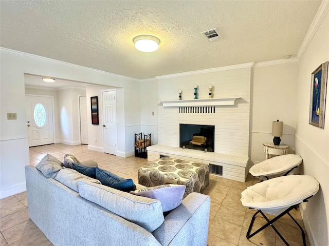 living room featuring a textured ceiling, light tile patterned floors, crown molding, and a brick fireplace