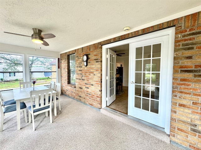 unfurnished sunroom featuring ceiling fan