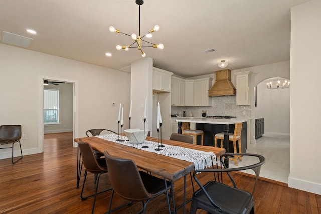 dining area featuring hardwood / wood-style floors and a notable chandelier