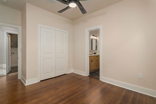 unfurnished bedroom with a closet, ceiling fan, dark hardwood / wood-style floors, and ensuite bathroom