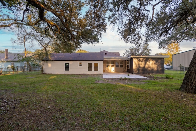 rear view of house featuring a patio and a yard