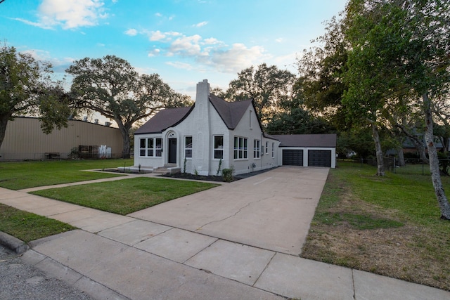 view of front of home featuring a front lawn, a garage, and an outdoor structure