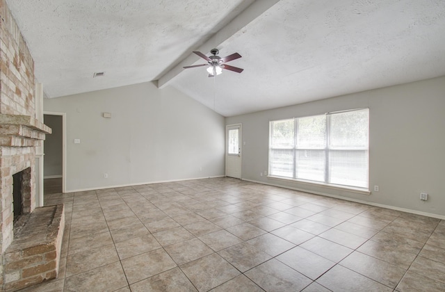 unfurnished living room featuring a brick fireplace, a textured ceiling, ceiling fan, light tile patterned floors, and vaulted ceiling with beams