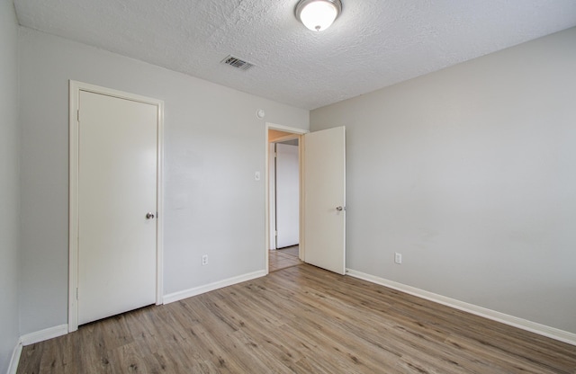 unfurnished bedroom featuring a textured ceiling and light wood-type flooring