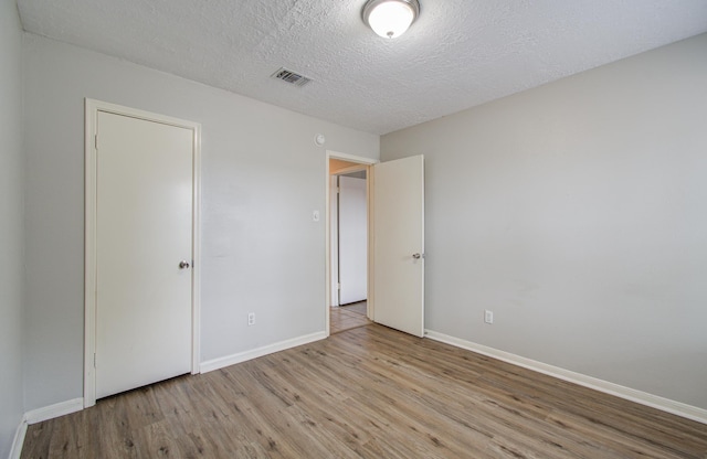 2046 Lexington Woods Dr, Spring, TX 77373 - unfurnished bedroom with wood finished floors, baseboards, and a textured ceiling