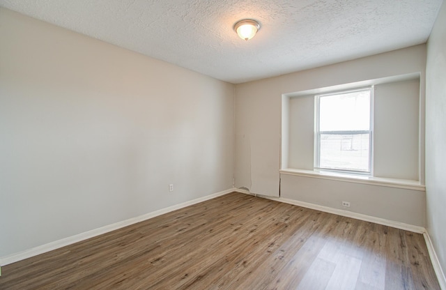 unfurnished room featuring a textured ceiling and hardwood / wood-style flooring