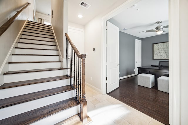 staircase featuring hardwood / wood-style floors and ceiling fan