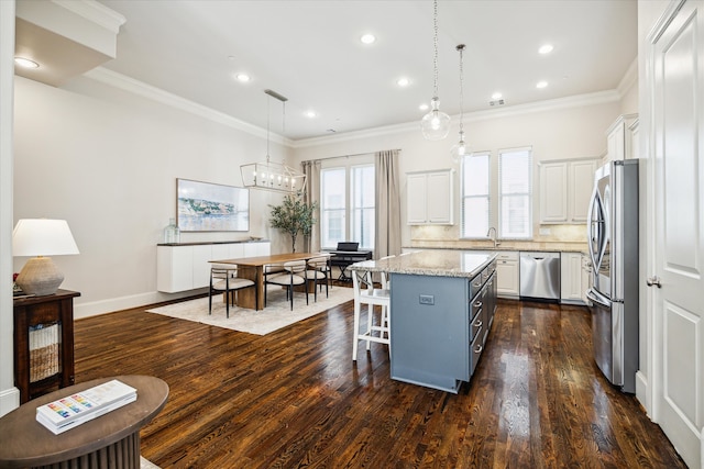 kitchen with stainless steel appliances, dark wood-type flooring, white cabinets, a kitchen island, and pendant lighting