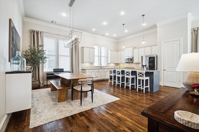 dining area featuring dark hardwood / wood-style floors, plenty of natural light, sink, and crown molding