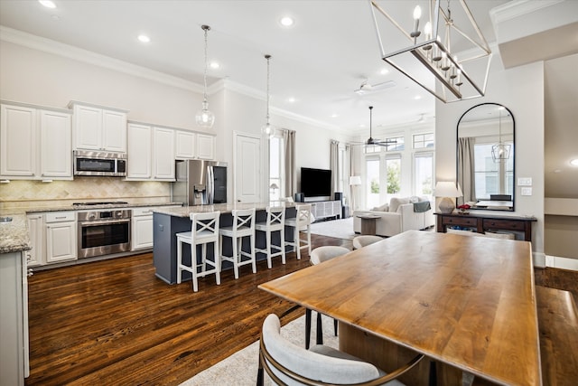 dining room featuring dark hardwood / wood-style flooring, ceiling fan, and crown molding