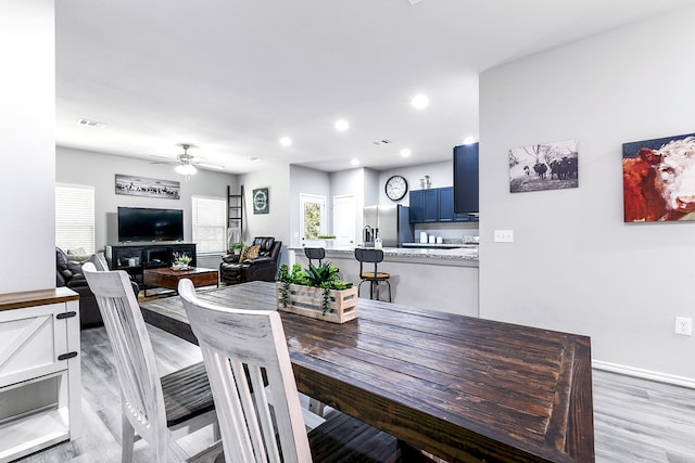 dining room with light wood-type flooring and ceiling fan