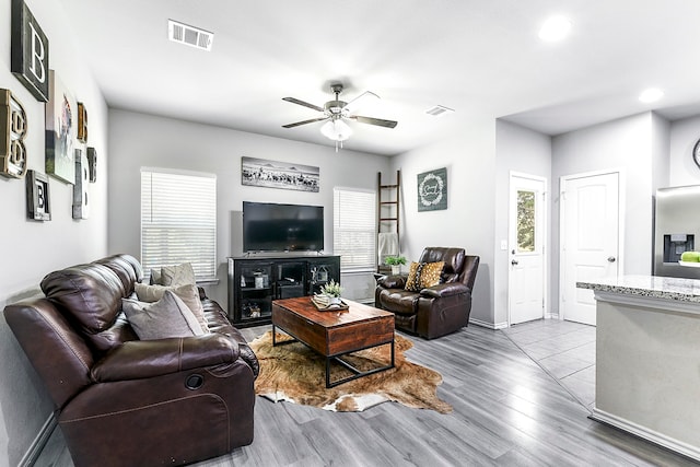 living room with light wood-type flooring and ceiling fan