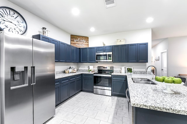 kitchen with blue cabinetry, sink, light stone counters, and stainless steel appliances