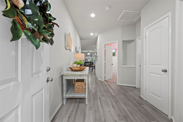 corridor with light hardwood / wood-style floors